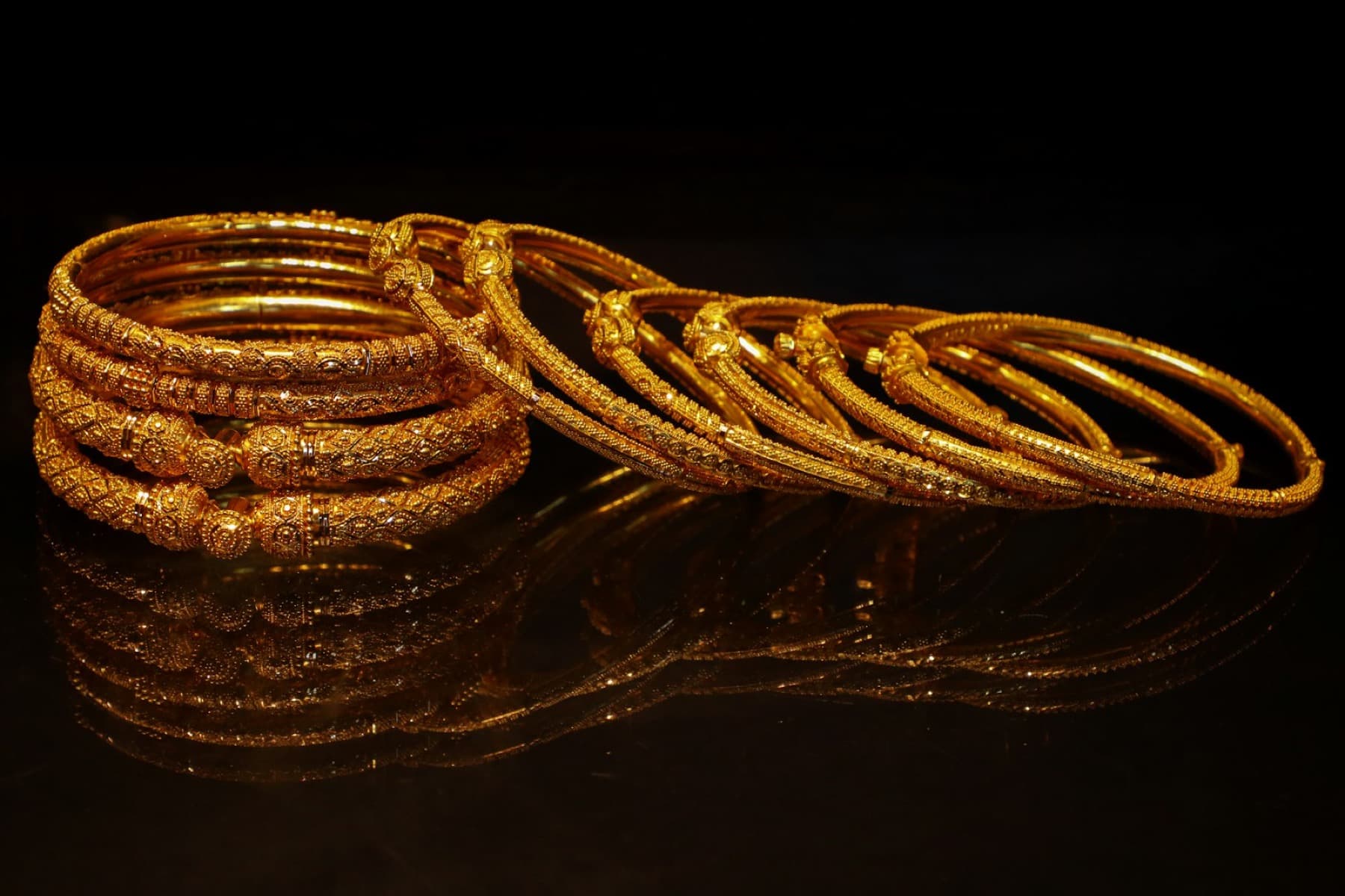 Gold bangles on a dark background